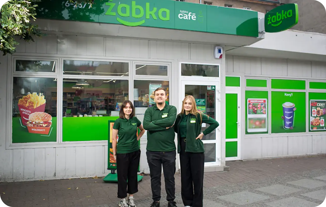 Uczestnicy programu stażowego przed nowoczesnym sklepem Żabka.