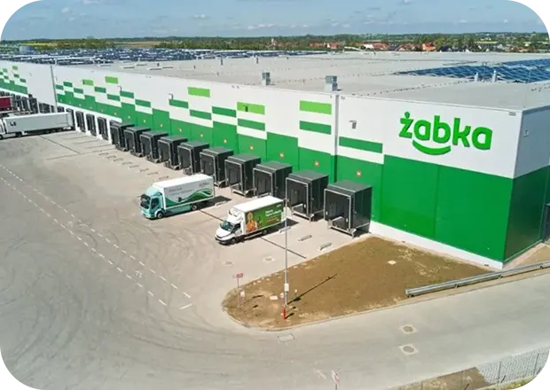 Pracownicy logistyki w zielonych kaskach ochronnych